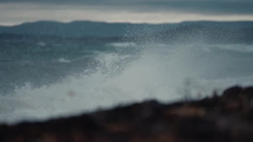 A storm on the fjord. Waves powered by heavy wind violently hit the shore. Water spray and foam fly