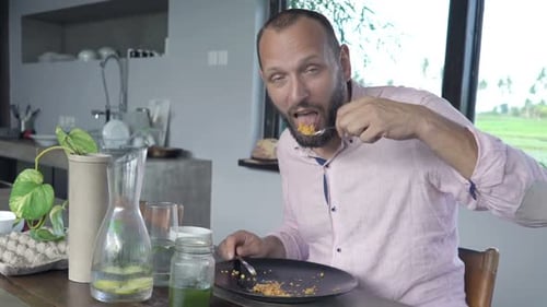 Man Enjoying Meal at Home Kitchen Table