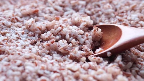 Close Up of Tan Rice Grains with Spoon