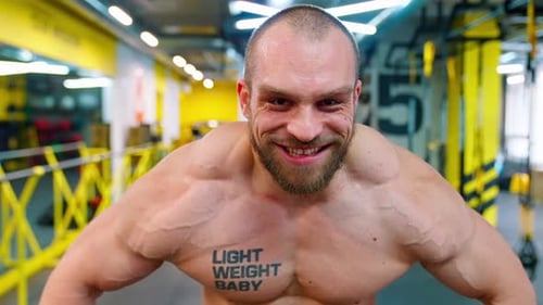 Muscular Man Flexing in a Modern Gym
