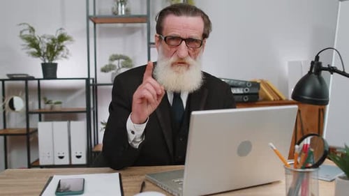 Senior Man Typing at Laptop in Modern Office