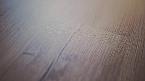 Close-up shot of a wooden floor, highlighting its natural texture, grain patterns, and aged details.