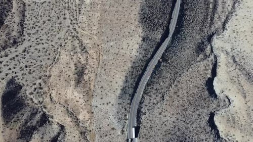 California Desert Road with Few Vehicles Passing By Under the Clear Sky