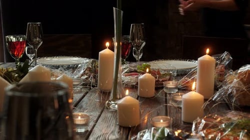 Woman Arranging and Lighting Candles on Dinner Table