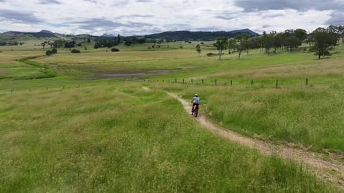 Dirt Biker Riding on Grassy Hillside Trail