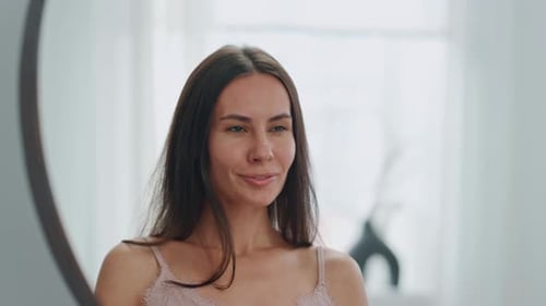 Woman Smiling in Mirror in Light Filled Home