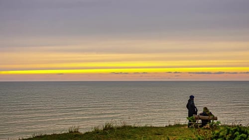 Time lapse romantic couple on bench enjoy sunset over ocean