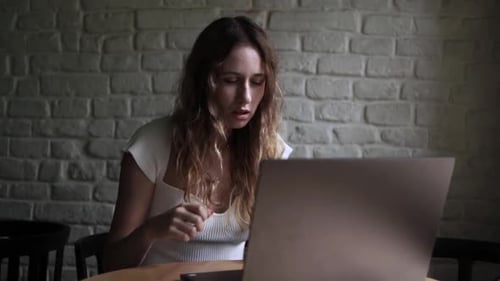 Young Woman Working on Her Laptop Computer in Coffee Shop