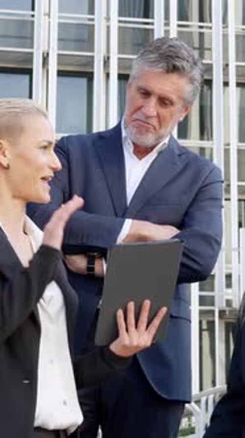 Business Colleagues Discussing Work with Tablet Outside