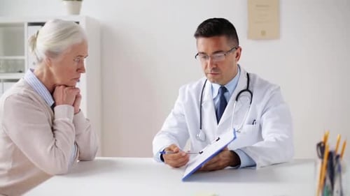 Caring Doctor Talking to Senior Patient in Office