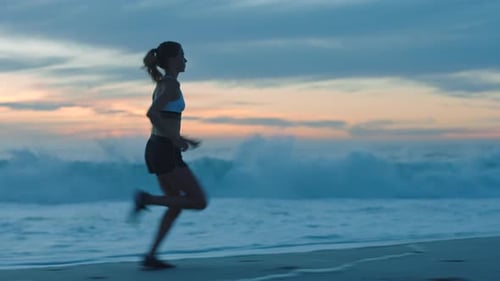Active, fit and fast athlete running, jogging and sprinting on a beach at sunset