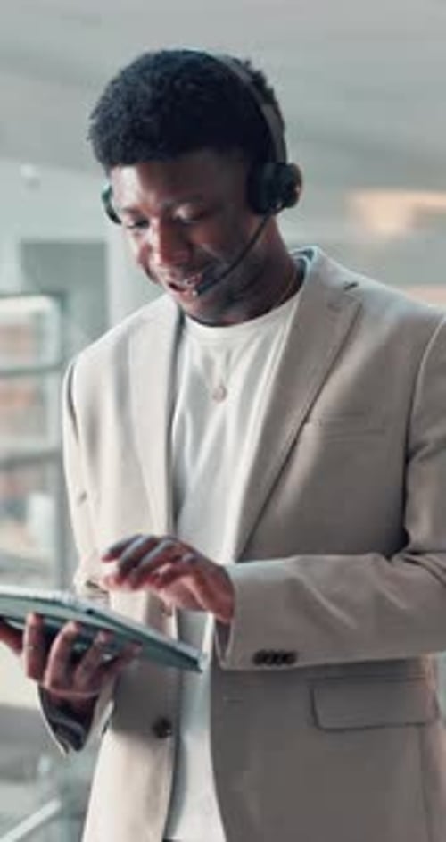 Young Adult Man Using Tablet With Headset On