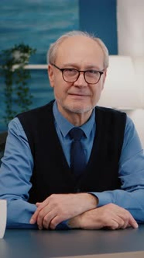 Adult Man Talks On Camera at Desk