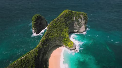 Rocky headland in the ocean with perfect sandy beach on tropical island in Indonesia.