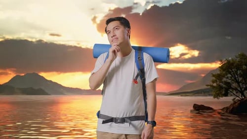 Asian Male Hiker Thinking About Something And Looking Around At A Lake