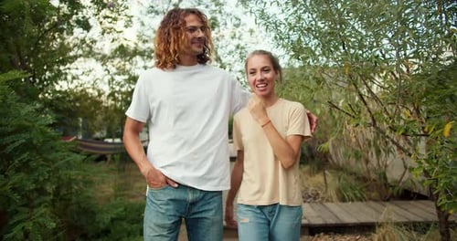 A Girl with Her Curly Boyfriend in a White Tshirt are Walking and Talking Alone to Each Other in the