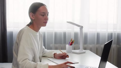 Young Woman Studying at Desk with Laptop