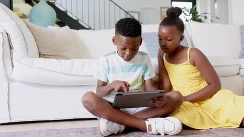 Brother and Sister Using Tablet Together at Home