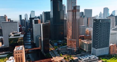 Channel with multiple bridges over it flowing through the cityscape of Chicago.