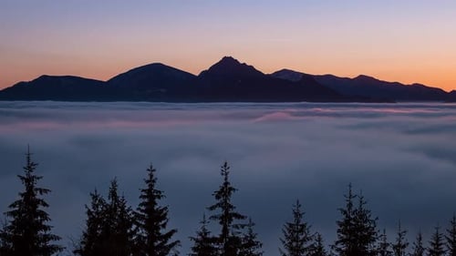 Majestic Mountain Peaks Rising Above A Thick Sea Of Clouds