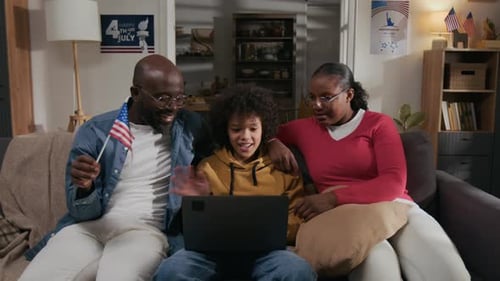 Family Celebrates Fourth of July at Home with Laptop