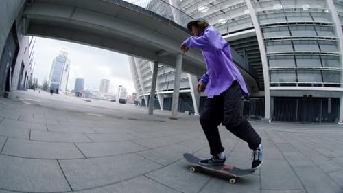 Bottom View of Skater Guy Jumping on Skateboard on City Street In