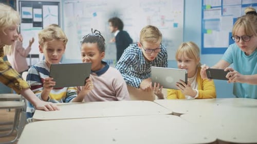 Informatikunterricht in der Schule: Schulkinder nutzen digitale Tablet-Computer und Smartphones mit August