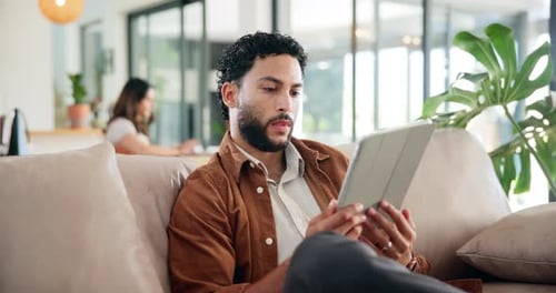 Thinking, relax and tablet with man on sofa for social media post, reading and online update