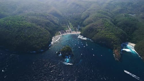 Vista desde arriba de la isla de Nusa Penida y el océano con el paisaje costero de la playa de Crystal Bay con colinas verdes