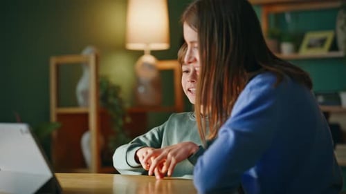 Child and Woman Using Tablet at Table Indoors