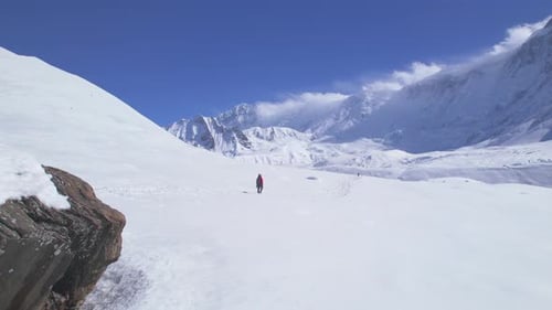 Aerial Revealing View Male Trekker in Red Jacket Walk Downhill From Hill Top on Tilicho Lake Camp