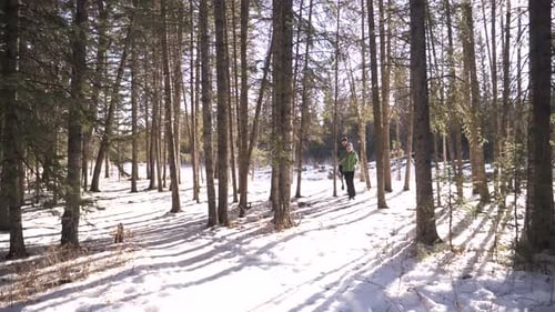 Couple on winter run slips and slides through snowy forest in Canada slow motion