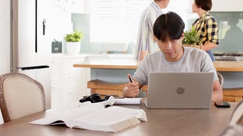 Young Man Studying at Kitchen Table