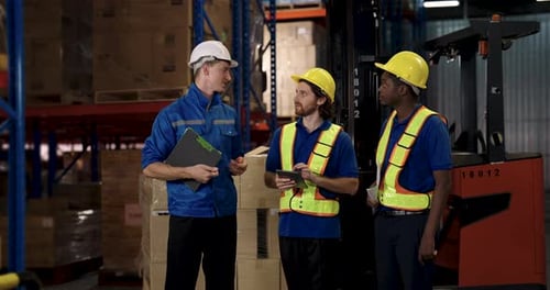 warehouse team reviewing task progress as african american worker communicates with caucasian