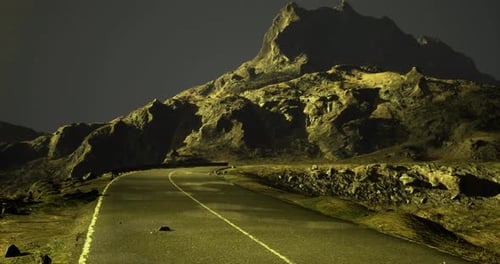 Road Winding Around Rocky Mountains at Twilight in a Remote Landscape