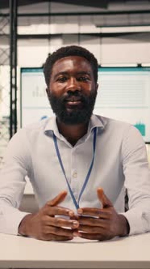 Professional Man in Office Presenting to Camera