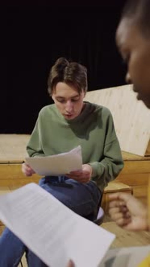 Junger Schauspieler lernt bei der Theaterprobe Drehbuch mit Partnerin