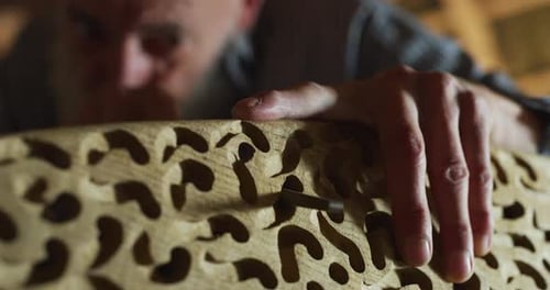 Close up of a carpenter while he is bucking a wooden board after he finished to cut it. Concept: W