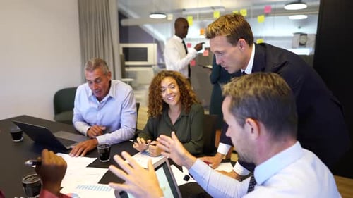 Manager explaining ideas to diverse business team in modern office boardroom
