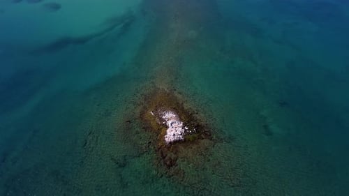 a Small Uninhabited Island Made of Stones in the Middle of the Aegean or Mediterranean Sea Drone