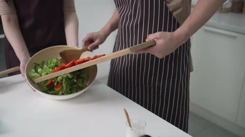 Couple Preparing a Fresh Salad in Kitchen