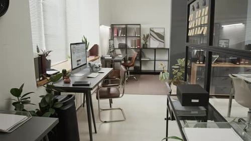 Well-Organized Office Space with Two Work Desks, Chairs, Potted Plants and Rack