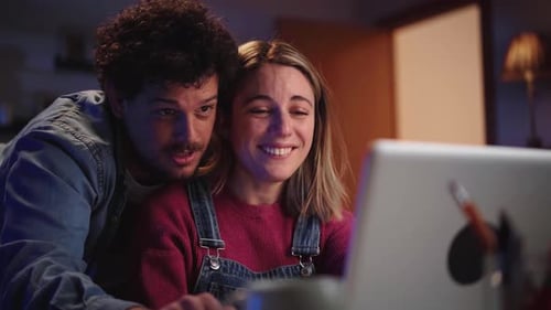 Young Couple Using Laptop Computer at Home at Night