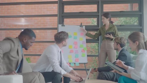 Pretty Asian business woman stand also hold tablet to present the progression of the project