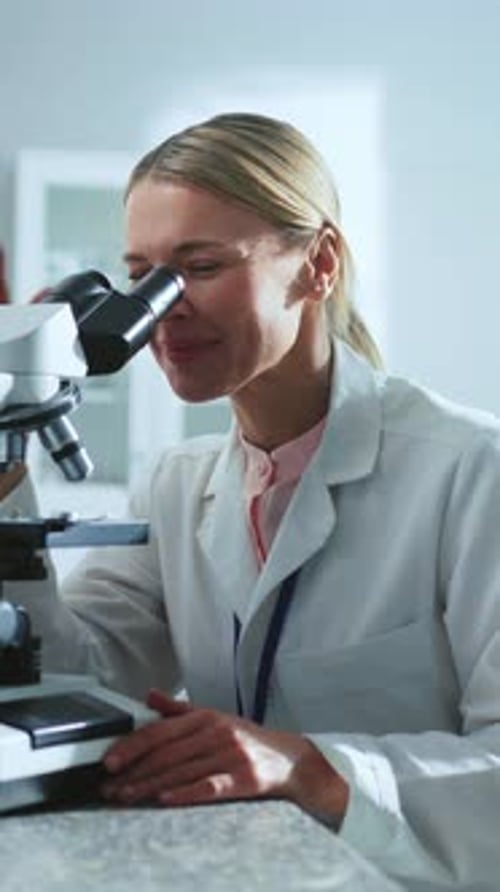 Woman Scientist Using Microscope in Bright Lab