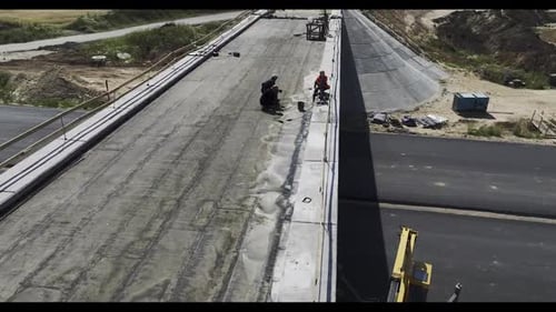 Builders Work on Bridge Over Road at Construction Site