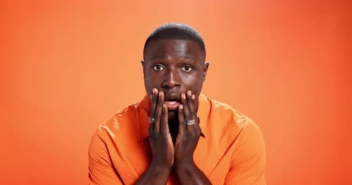 Black man, studio and shocked face or expression on orange background for wow, rumor or gossip