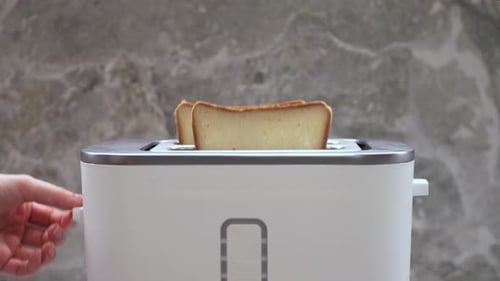 Placing Bread Slices into a Modern Toaster