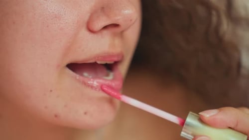 Young Woman Beautifying in Hotel Room Closeup of Woman Applying Lip Gloss Carefully Female Preparing