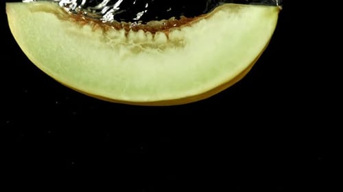 Un morceau de melon tombe sous l'eau filmé par une caméra à haute vitesse à 1000 images par seconde